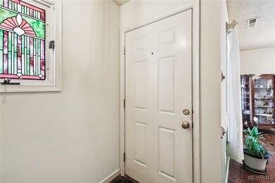 Doorway to outside featuring a textured ceiling and dark wood-style flooring