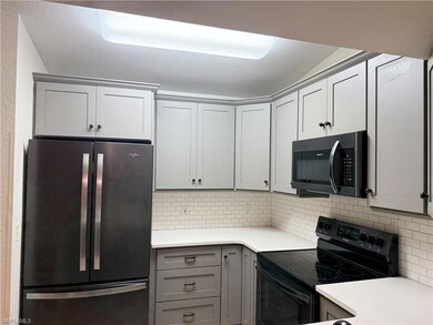 Kitchen featuring gray cabinetry, decorative backs