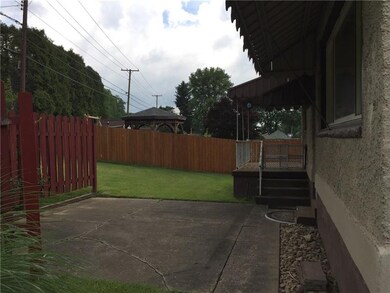 Covered back porch and cement patio with privacy f