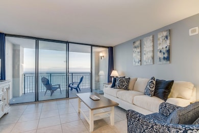 Living room featuring a water view, light tile pat