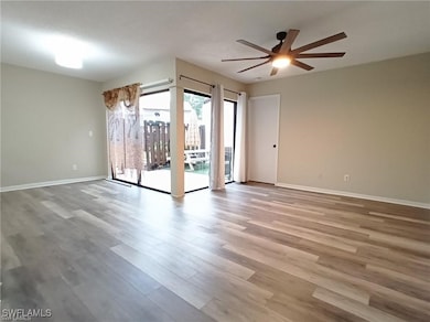 Spare room with baseboards, a ceiling fan, and woo