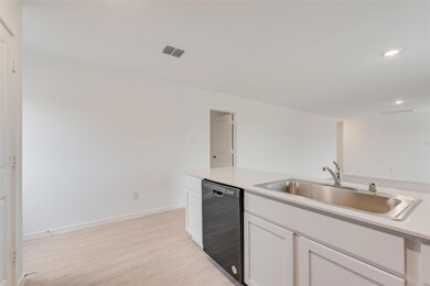 Kitchen with a sink, visible vents, white cabinets
