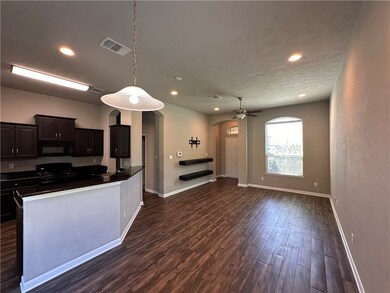 Kitchen with gas range oven, baseboards, black mic