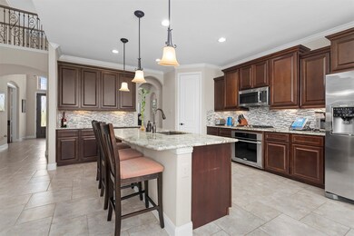 Have a sneak peak at this fabulous kitchen which includes an oversized island with breakfast bar. Take a look to the left here, and you will see the entry way and stylish cat walk upstairs.