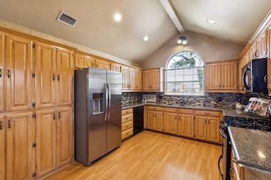 This cheerful kitchen benefits from the vaulted ceiling giving an open feeling and the large window looking toward the front yard. Notice there is fantastic storage. The refrigerator will convey with the home.