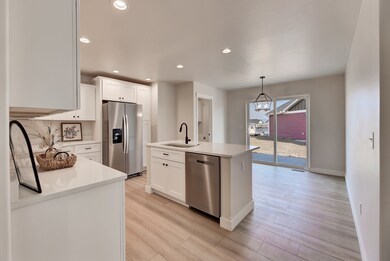Kitchen featuring stainless steel appliances, an island with sink, recessed lighting, a chandelier, and white cabinetry