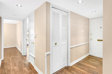 Hall with light wood-type flooring and recessed lighting