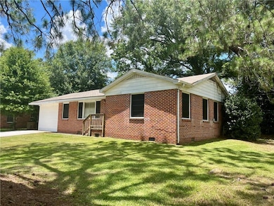 Ranch-style home featuring crawl space, brick siding, and a front lawn