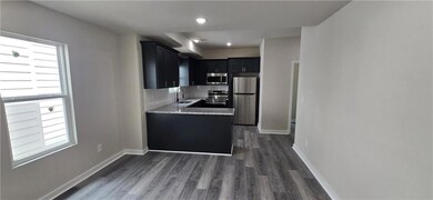 Kitchen with baseboards, dark cabinets, a sink, da