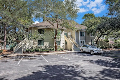 View of property with stairway and uncovered parking