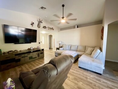 Living room with arched walkways, a ceiling fan, l