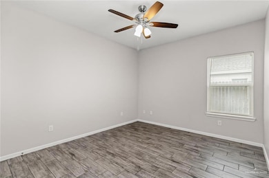 Empty room featuring baseboards, ceiling fan, and wood finished floors
