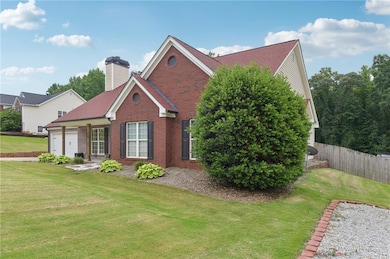 View of front of property featuring brick siding, an attached garage, and a chimney