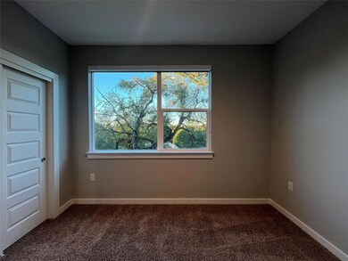 Unfurnished room with dark carpet and baseboards