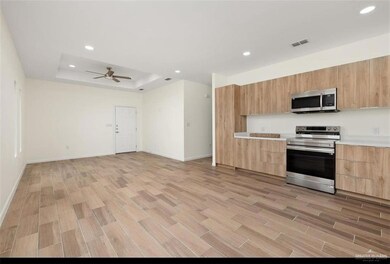 Kitchen with stainless steel appliances, modern cabinets, light brown cabinets, and visible vents