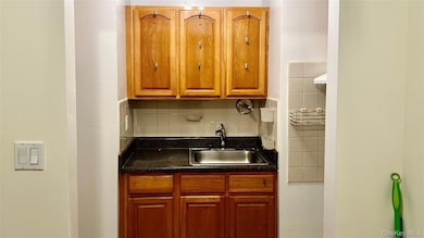 Kitchen featuring dark countertops, backsplash, and brown cabinets