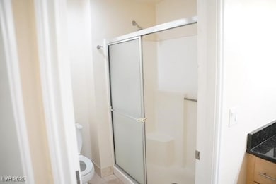 Full bathroom featuring a stall shower and toilet