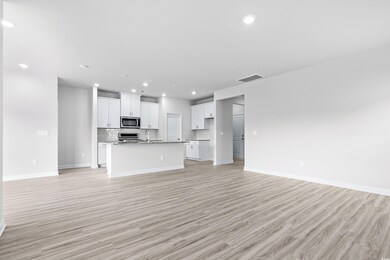 Unfurnished living room featuring light hardwood /