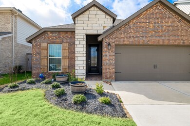 Attractive brick and stone elevation with dark garage door. Home is East facing.