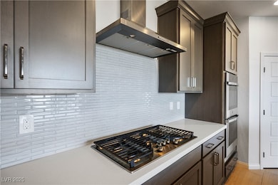 Kitchen featuring wall chimney range hood, applian