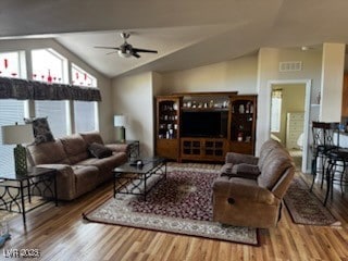 Living room featuring vaulted ceiling, wood finish