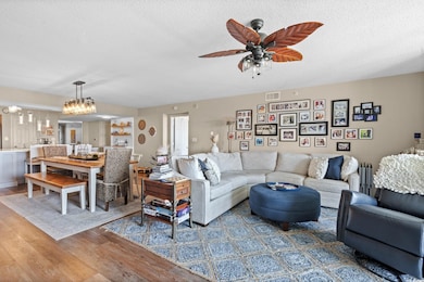 Living room with wood finished floors, a textured ceiling, and a ceiling fan