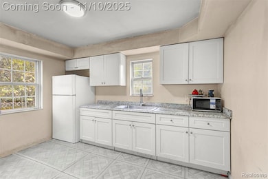 Kitchen featuring white electric range, white cabinets, light countertops, and light wood-type flooring