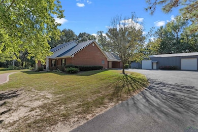 View of home's exterior with brick siding, a nice 30x50 shop, and an attached 2 car carport and storage room.