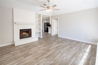 Living room with fireplace looking into kitchen