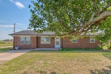 Single story home featuring a front yard, brick siding, and roof with shingles