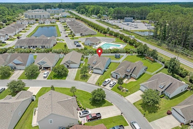 Aerial view of residential area featuring a nearby body of water and a heavily wooded area