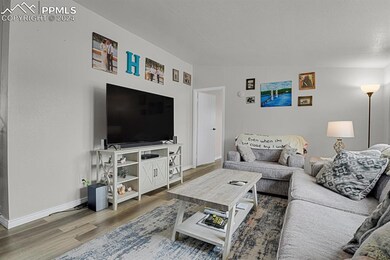 Living room featuring wood-type flooring and vault