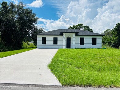 View of front facade with a front yard and driveway