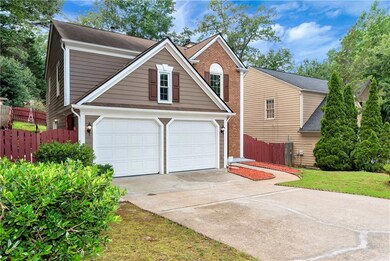 Traditional-style home with concrete driveway, brick siding, and a garage