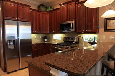 Kitchen features bar seating and gas range.