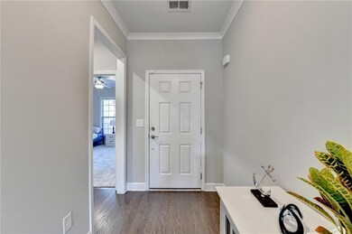 Entrance foyer featuring crown molding, ceiling fa