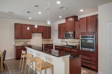 Kitchen with visible vents, pendant lighting, sta