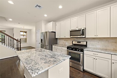 Kitchen featuring white cabinets, stainless steel