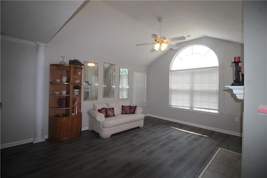 Living area with vaulted ceiling, a ceiling fan, and luxury vinyl flooring