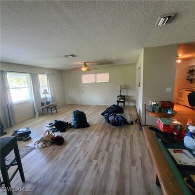 Living room featuring ceiling fan, a textured ceil