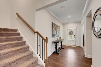 Foyer entrance with dark wood-style flooring, stai