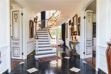 Foyer featuring crown molding, a notable chandelie