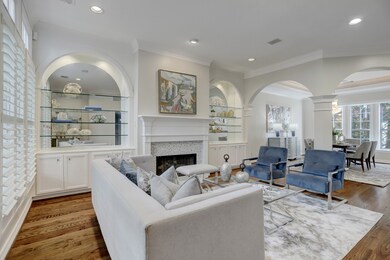 Spacious living and dining room offers elegance and sophistication with the extended crown moldings, 10 ft ceilings, built in glass shelving, refinished hardwood floors, tile fireplace surround and recessed lighting.