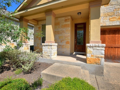 View of exterior entry with stone siding and covered porch