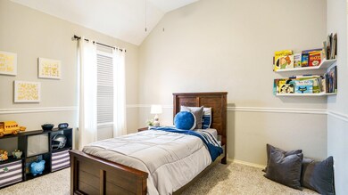 Carpeted bedroom featuring vaulted ceiling