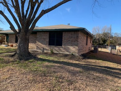 View of side of property with a yard and central AC