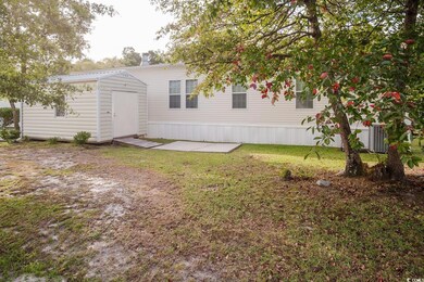 Rear view of property featuring a yard and a shed