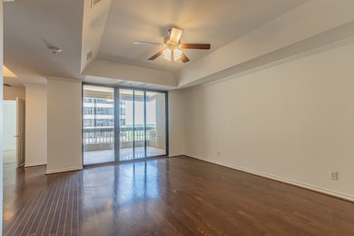 Spare room with floor to ceiling windows, a ceiling fan, dark wood-style floors, a raised ceiling, and ornamental molding