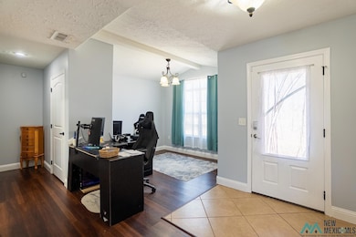 Tiled home office with a chandelier and a textured ceiling