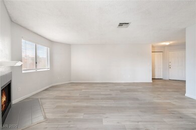 Unfurnished living room with a fireplace, a textur